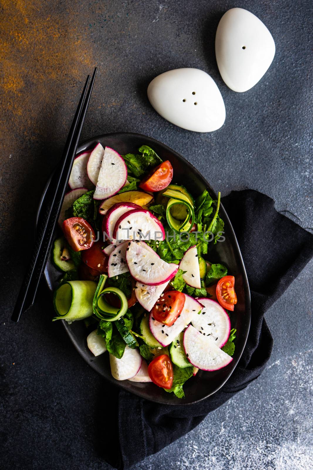 Healthy lifestyle food concept with mixed vegetable salad and seeds on rustic stone background with copy space