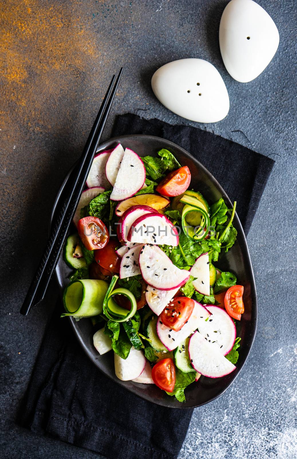 Healthy lifestyle food concept with mixed vegetable salad and seeds on rustic stone background with copy space