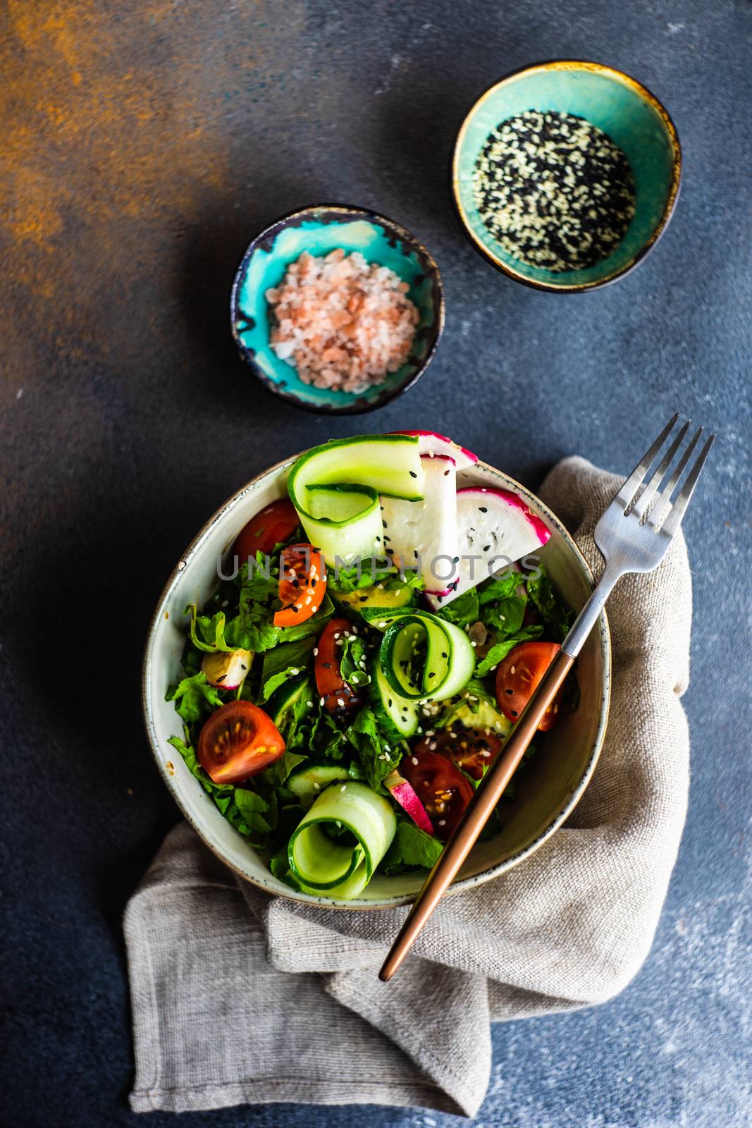 Healthy lifestyle food concept with mixed vegetable salad and seeds on rustic stone background with copy space