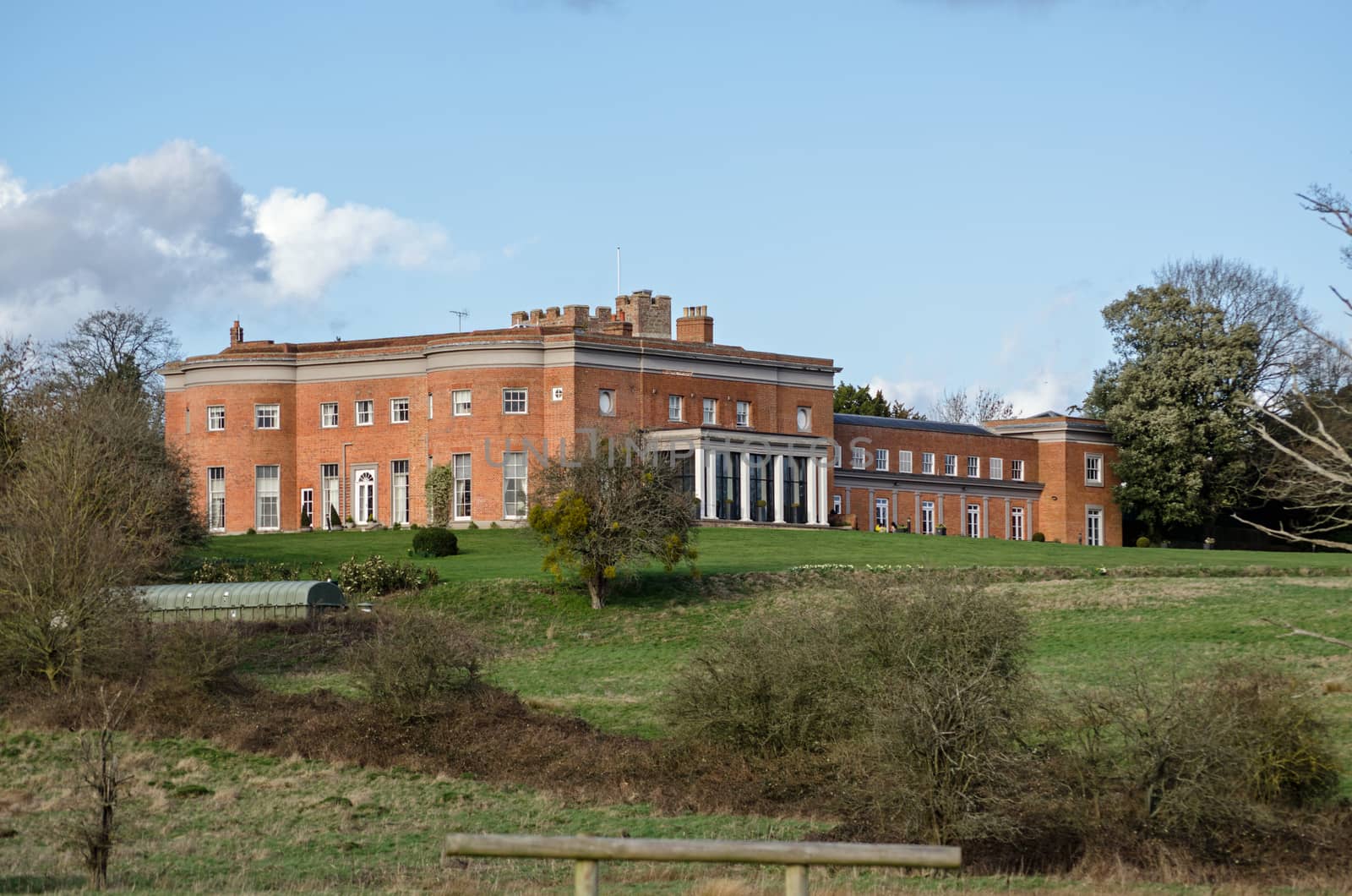 View across fields towards the historic Highfield Park stately home, now a hotel in the village of Heckfield, Hampshire. The former Prime Minister Neville Chamberlain lived and died here.  Built in the times of Queen Anne.  