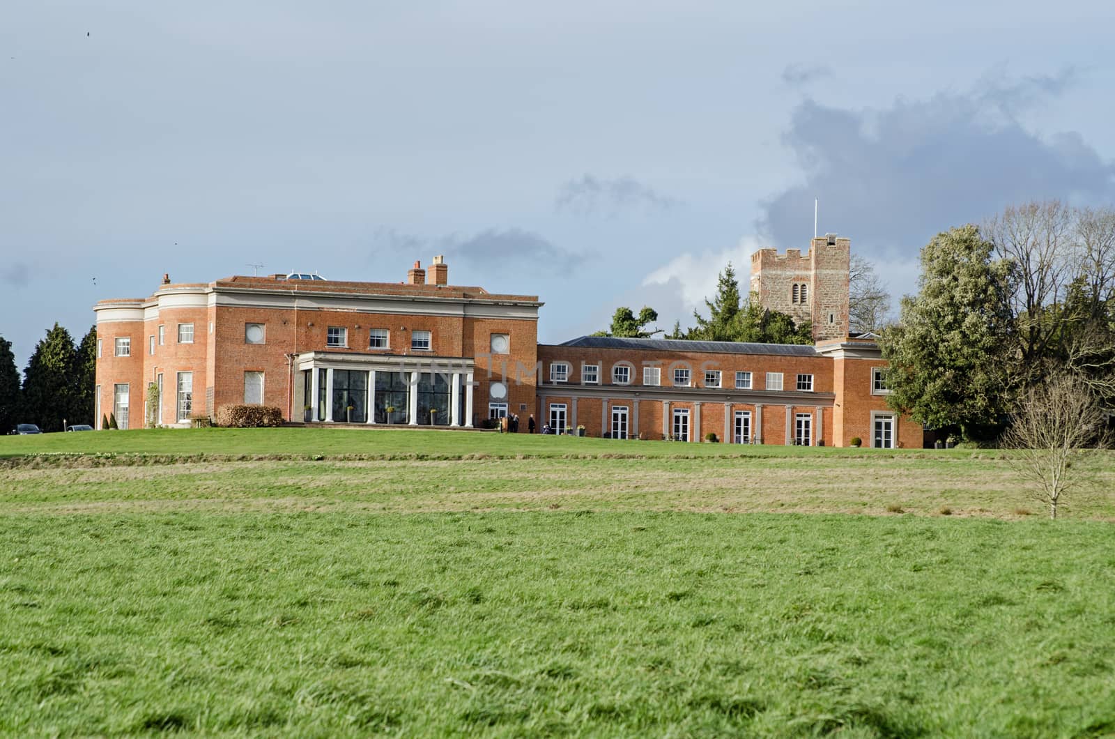 View across pasture towards the historic Queen Anne style stately home of Highfield Park in Heckfield, Hampshire.  Former Prime Minister Neville Chamberlain lived and died in this landmark house which dates back hundreds of years.