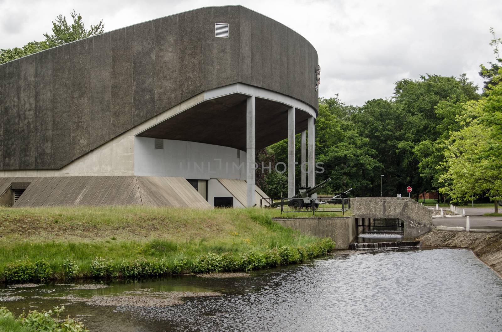 View of the brutalist Churchill Hall lecture theatre with the  Wish Stream brook running past at the Royal Military Academy in Sandhurst, Berkshire.