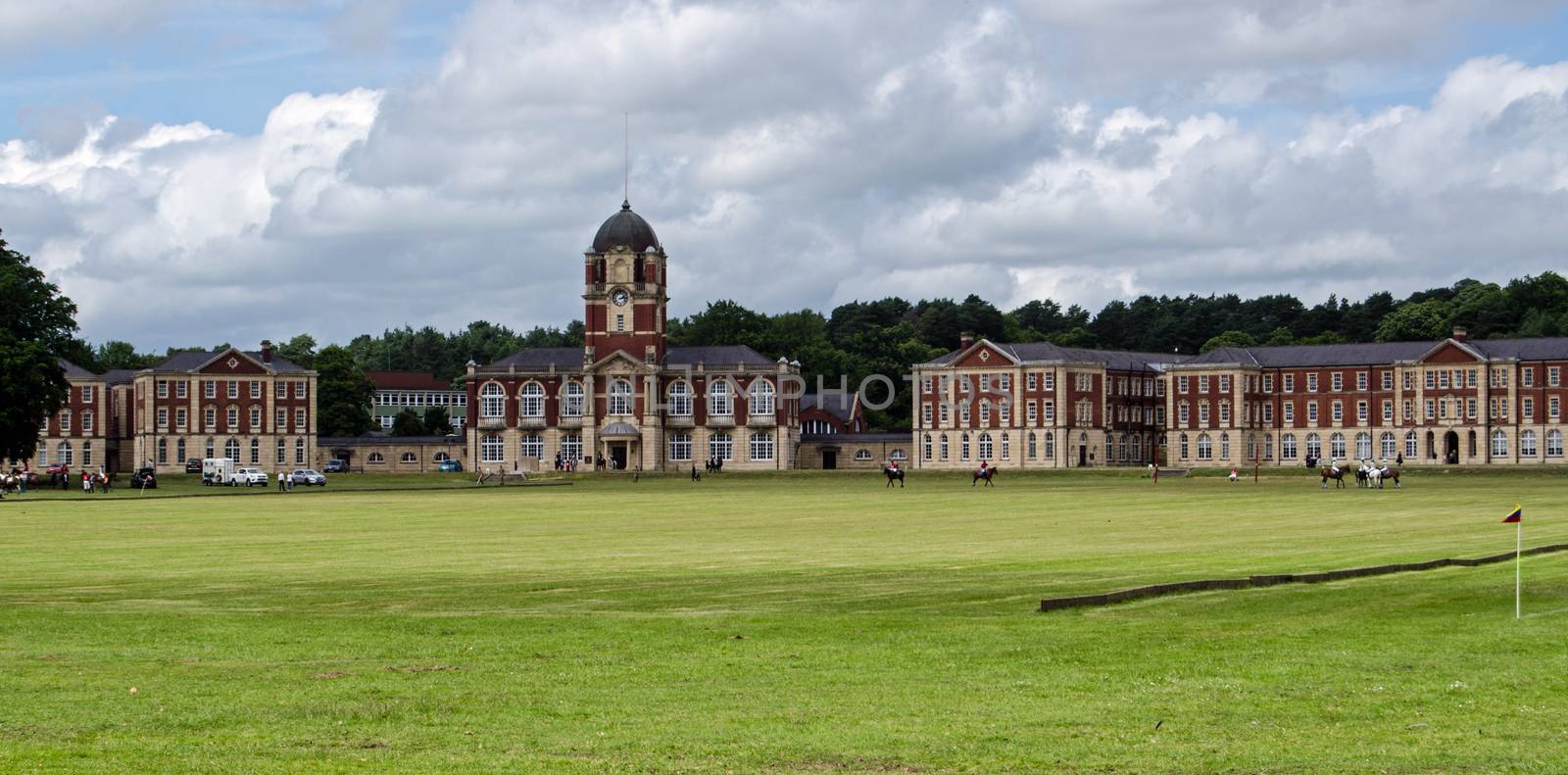 Horses and players preparing for a match on the polo field in front of New College at the Royal Military Academy, Sandhurst.  The Academy trains officers for the British Army.