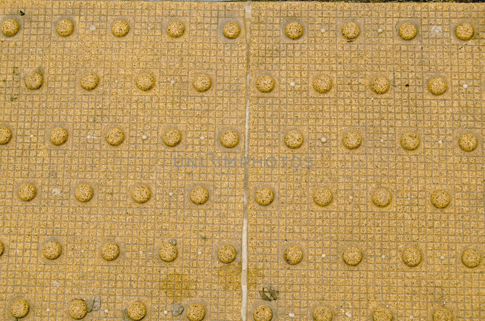 Detail of the internationally used tactile paving to help visually impaired people. These truncated domes are marking the edge of a railway platform.