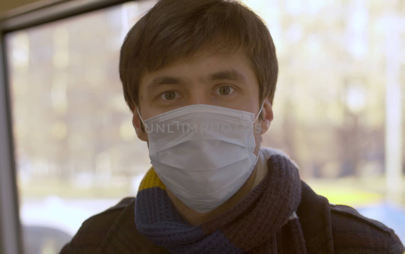 Close up portrait of a young handsome man in protective mask going by bus. Coronavirus epidemic. Concept of healthy and safety life.