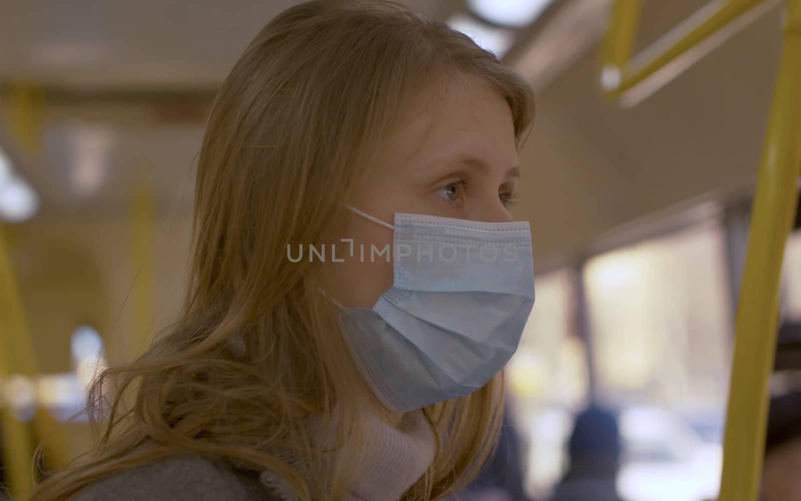 Close up portraits of a young handsome woman in protective mask traveling in the bus. Coronavirus epidemic. Concept of healthy and safety life.