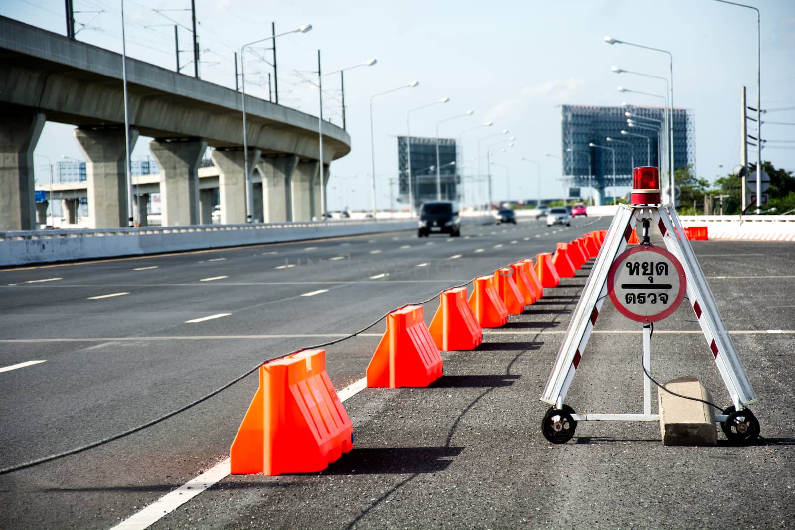 Stop road sign on a highway with traffic cars