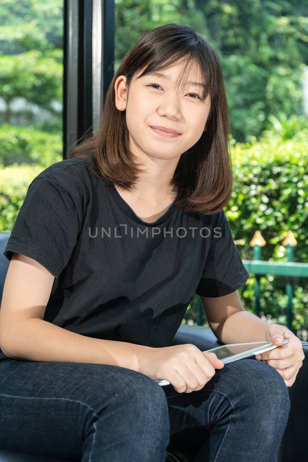 Student teenage studying online from digital tablet on the sofa at home