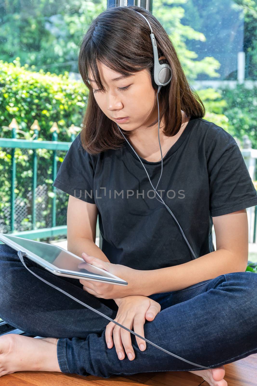 Happy teenage female  learning to the music from a digital tablet in room at home