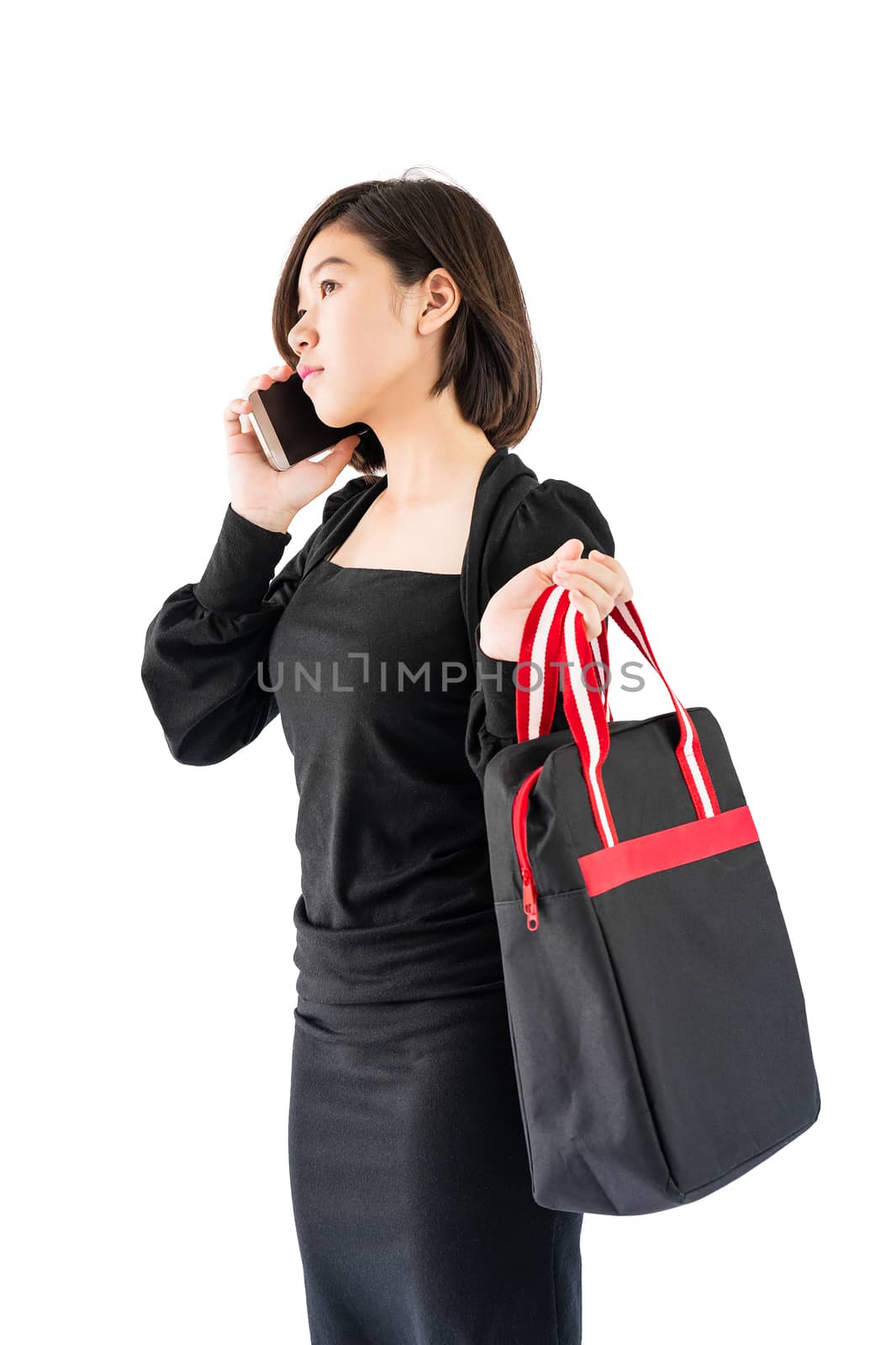 Woman carrying a black shopping bag using cellphone shopping onl by stoonn