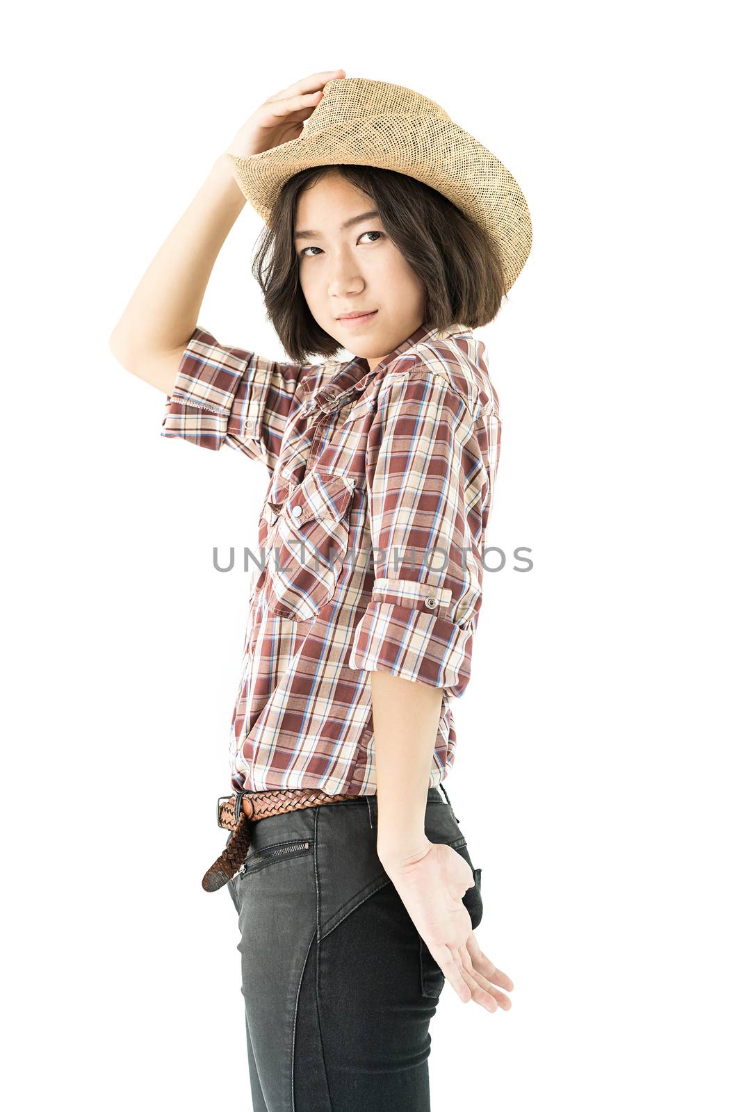 Young pretty woman in a cowboy hat and plaid shirt with hand on her hat isolated on white background