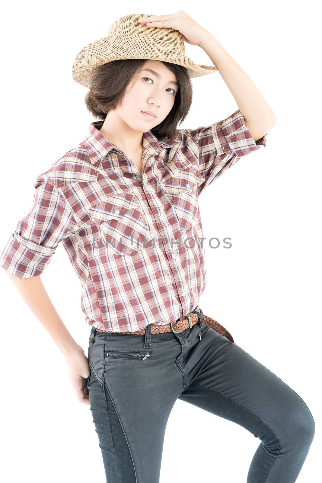 Young pretty woman in a cowboy hat and plaid shirt with hand on her hat isolated on white background