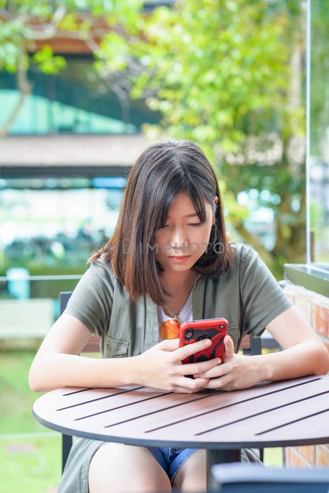 Pretty woman sitting in a cafe terrace use smartphone