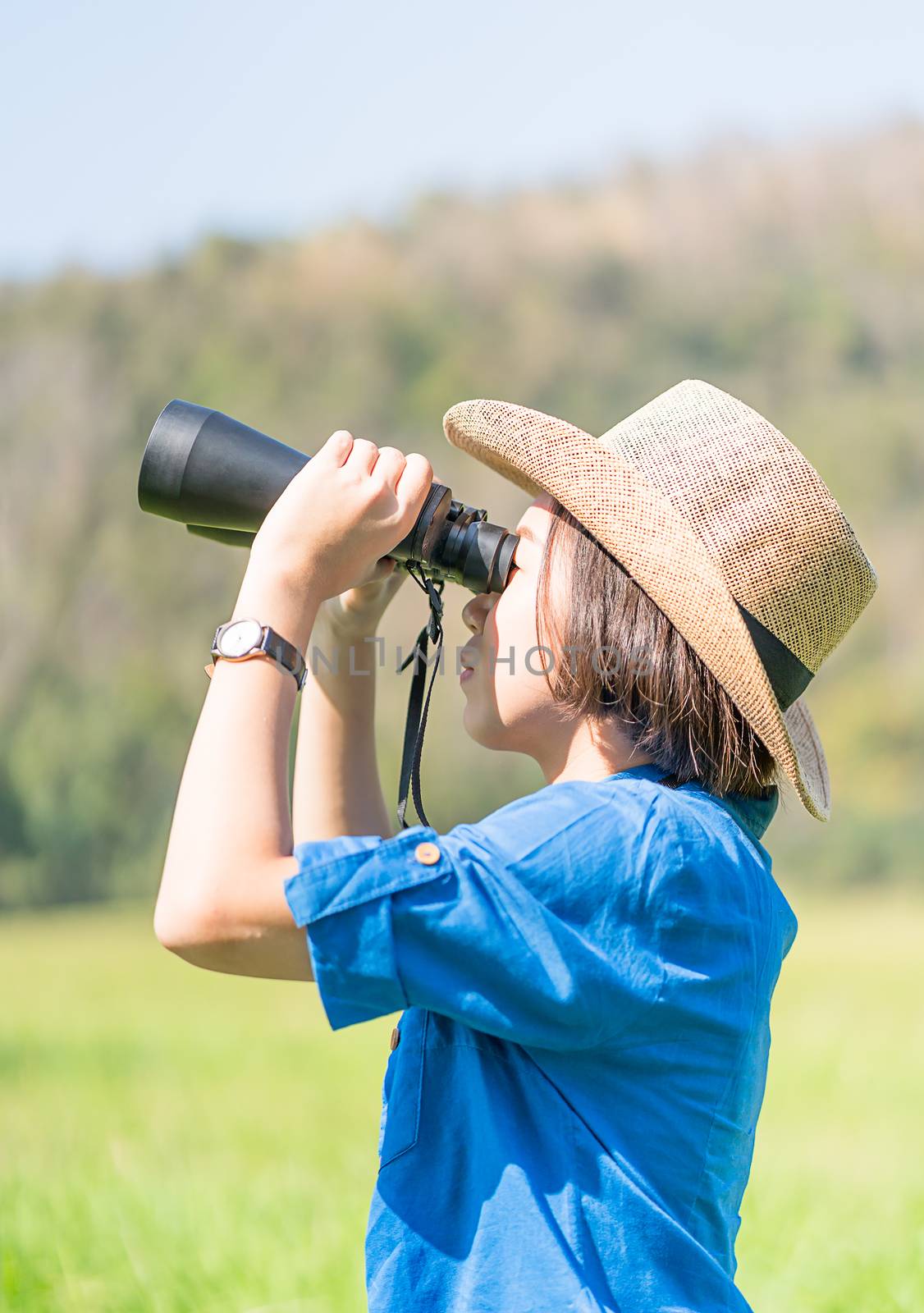 Woman wear hat and hold binocular in grass field by stoonn