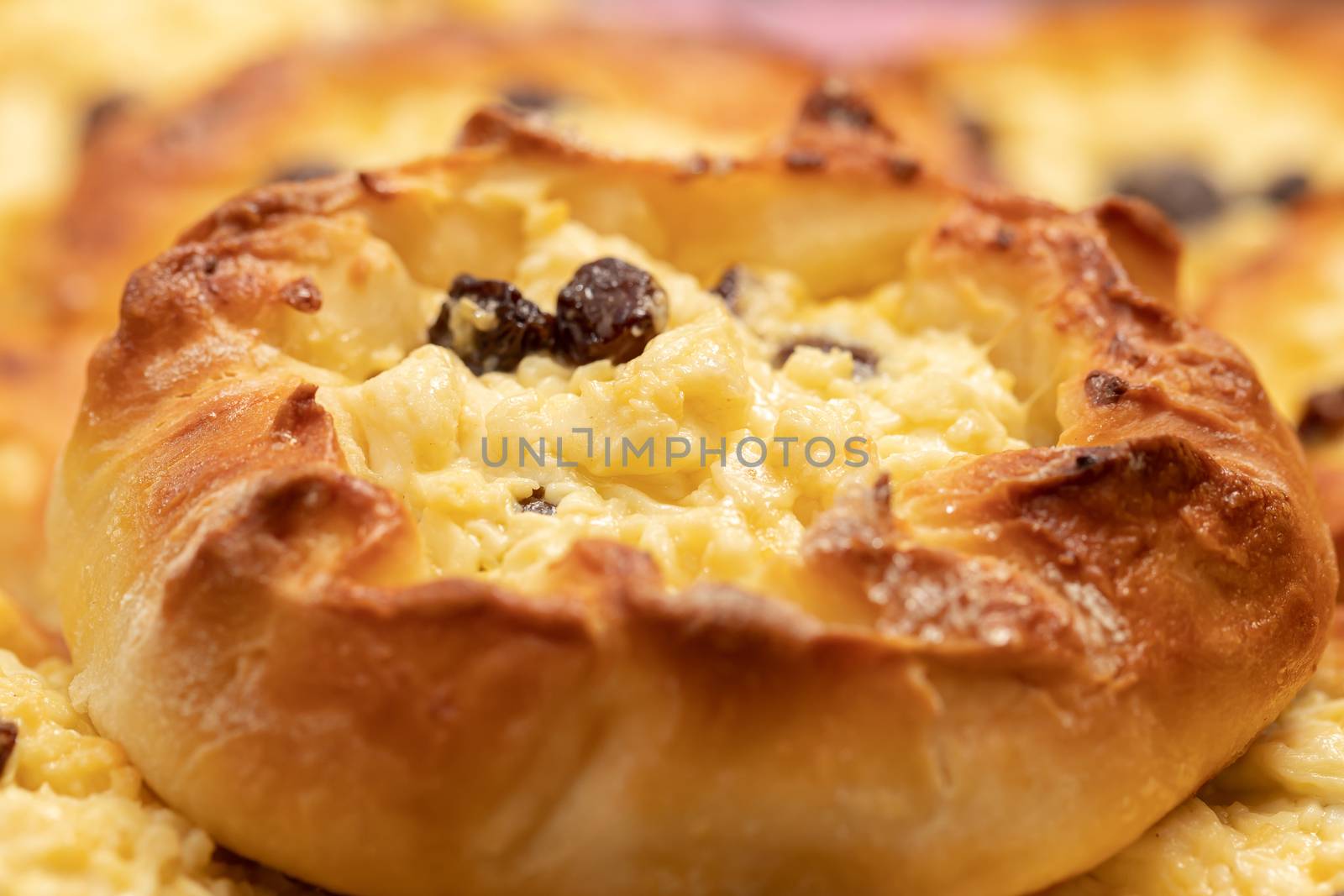 Fresh homemade open patties with cottage cheese (traditional Russian pastry vatrushka, round buns, curd tart) on linen napkin, white background, selective focus, closeup