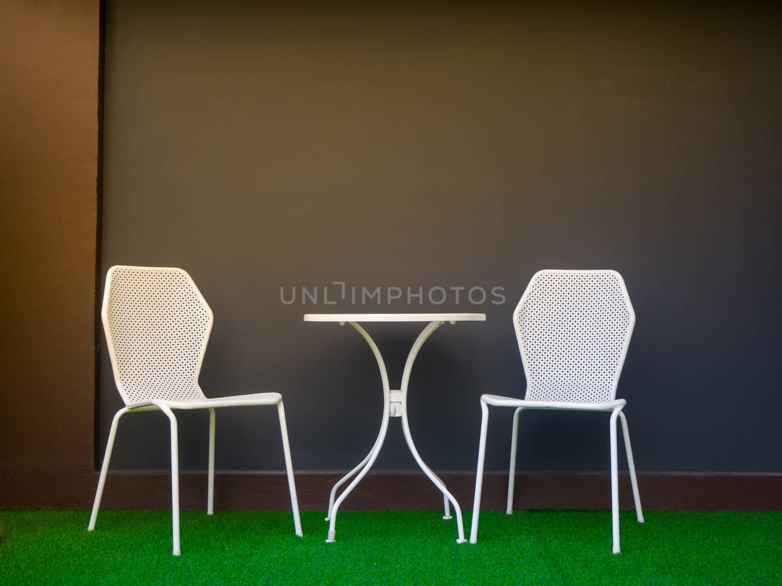 the tables and chairs in front of soft blue wall - Image by shutterbird