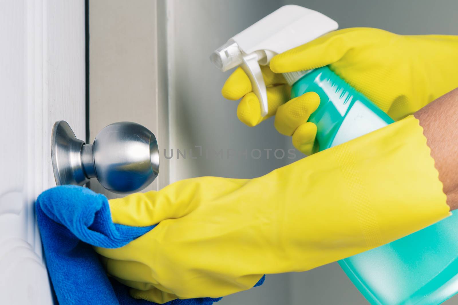 Cleaning door knob with alcohol spray for Covid-19 Coronavirus p by psodaz