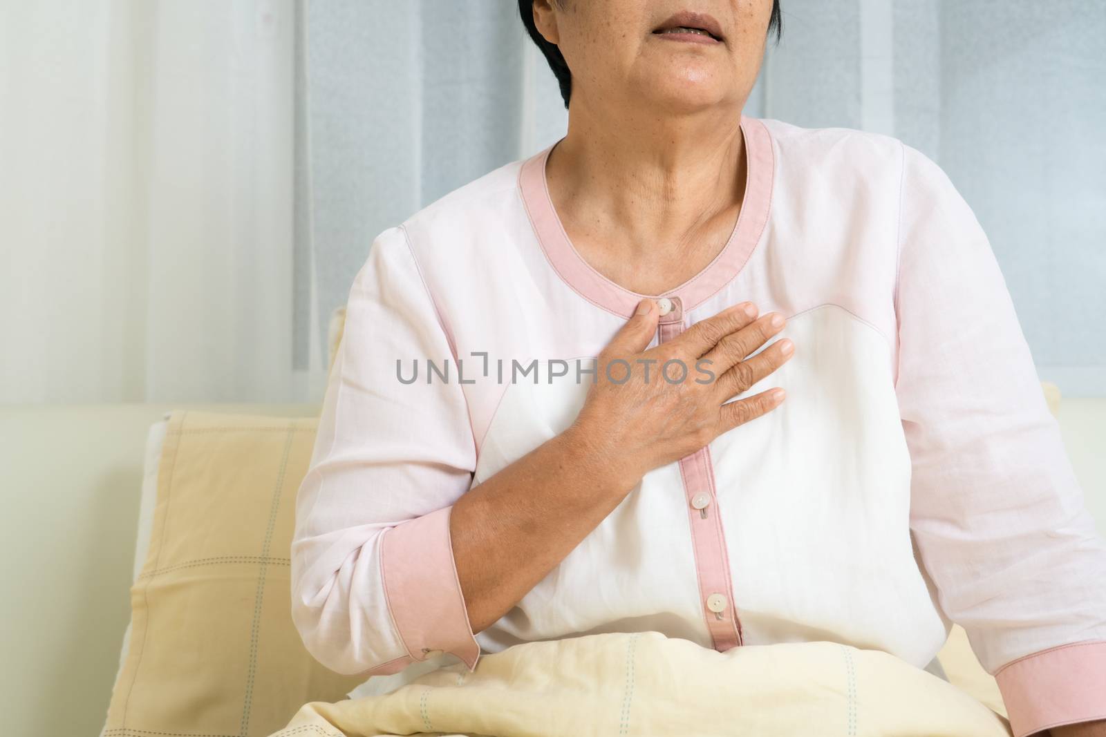 heart attack old woman holding chest in bed room, healthcare pro by psodaz