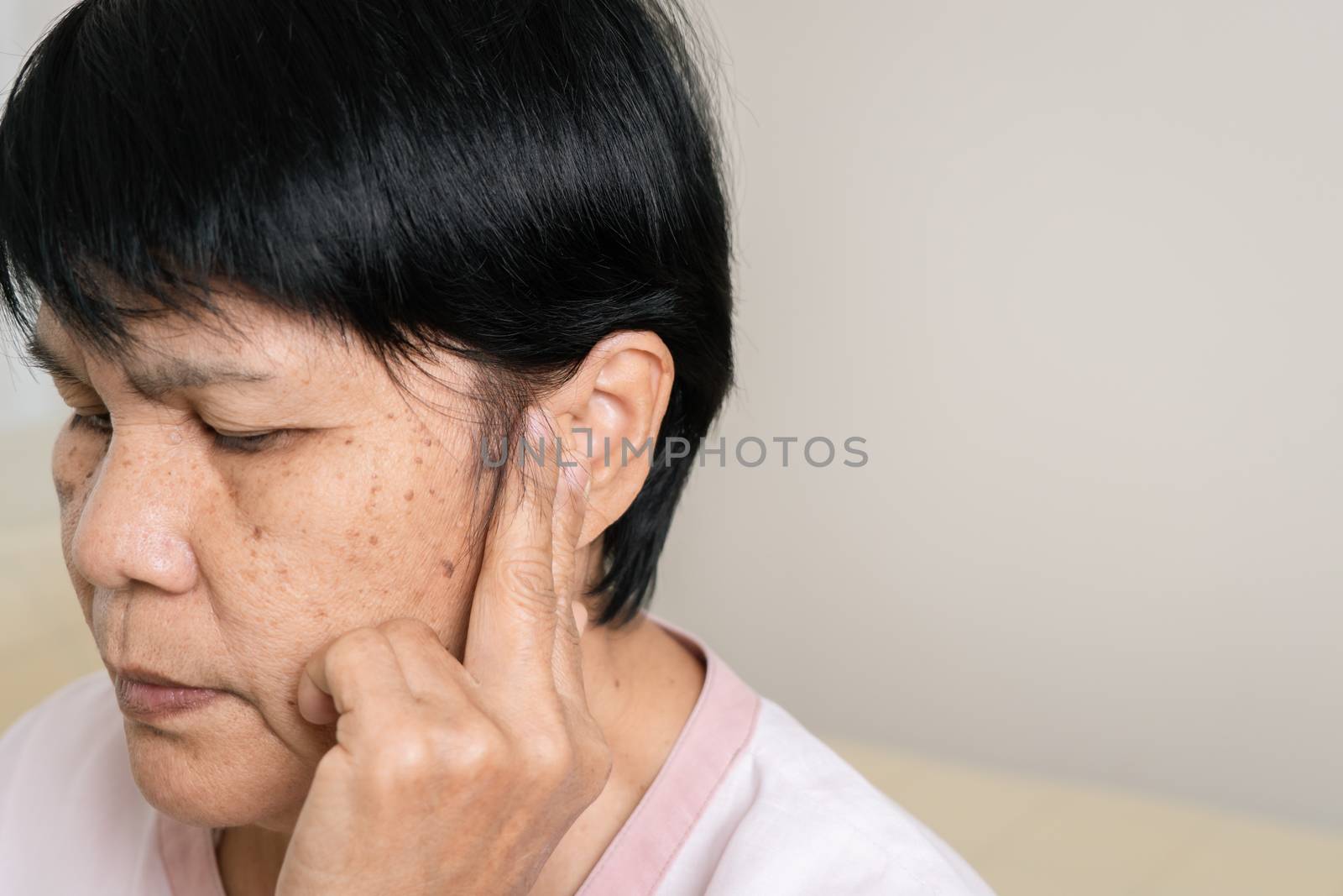 symptom of hearing loss of old woman. old woman couch with fingers near ear. healthcare problem of senior concept