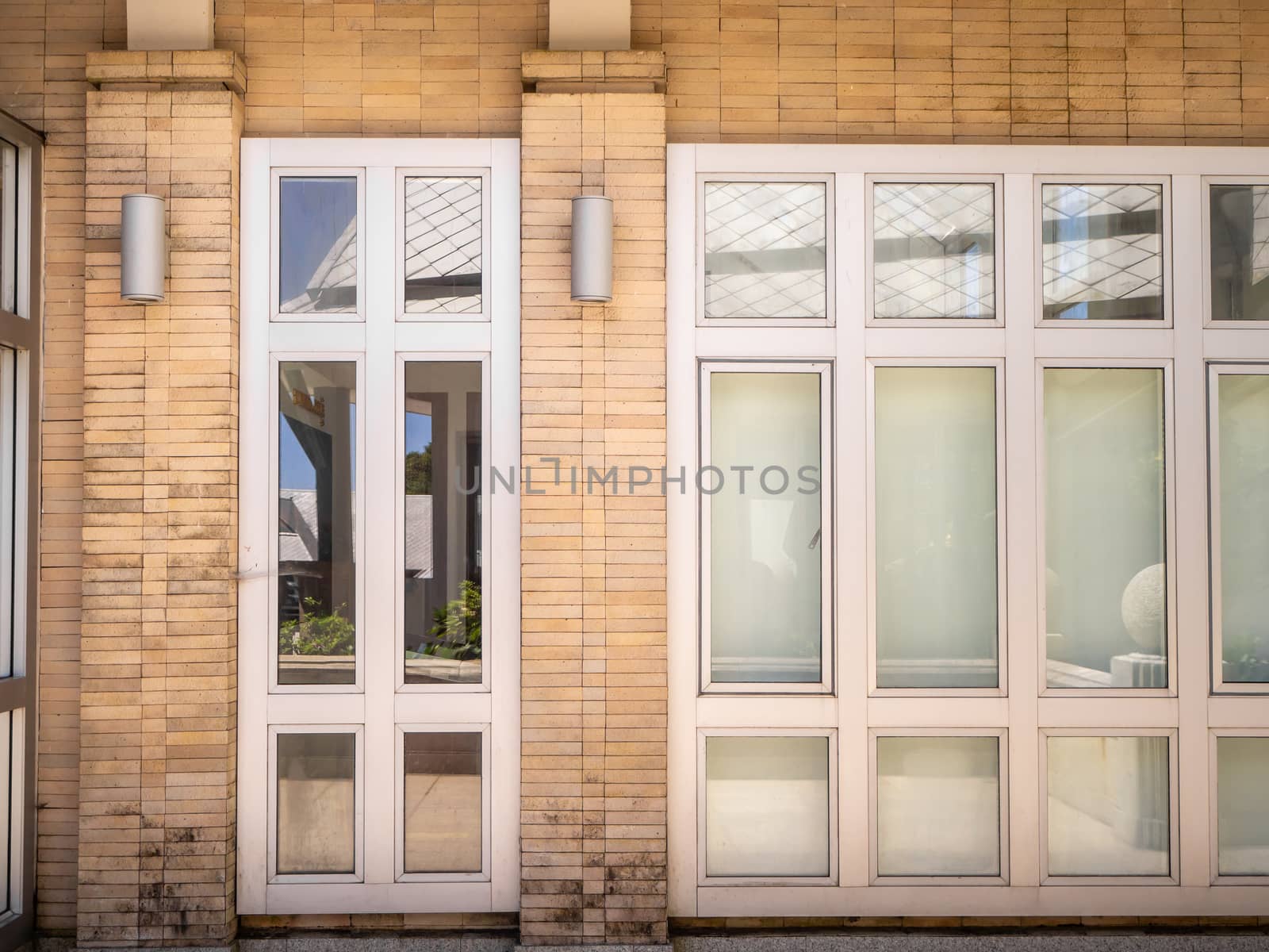 Glass windows and doors with turquoise frames at red bricked