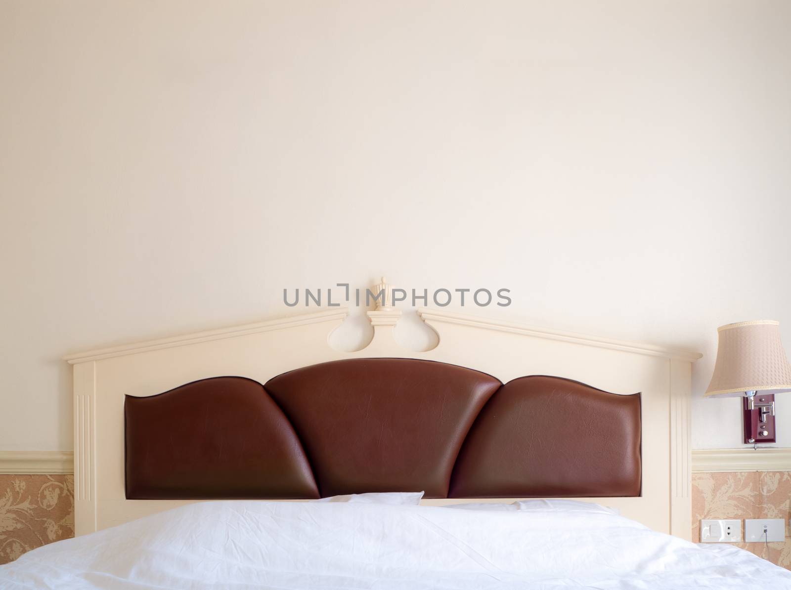 bedroom interior with pillows and reading lamp on bedside table