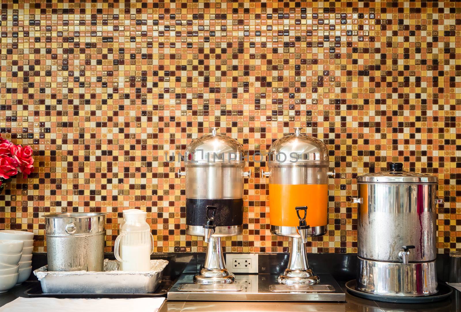 Fruit juice dispensers and coffee & tea water on a self service breakfast counter in a hotel.