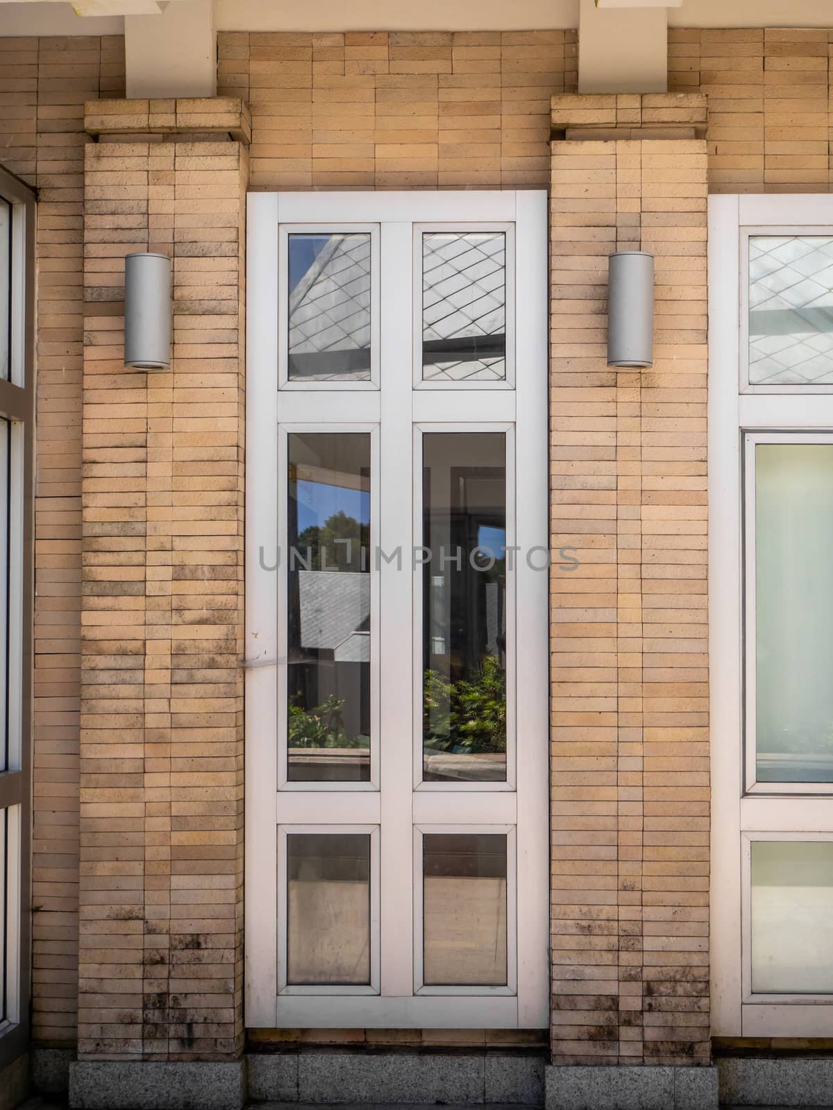 Glass windows and doors with turquoise frames at red bricked