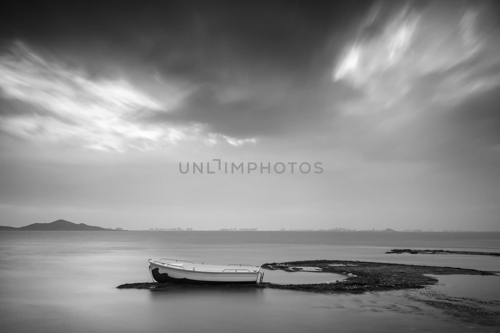 Lonely boat at dawn on the shores of the Mar Menor, Spain, in black and white