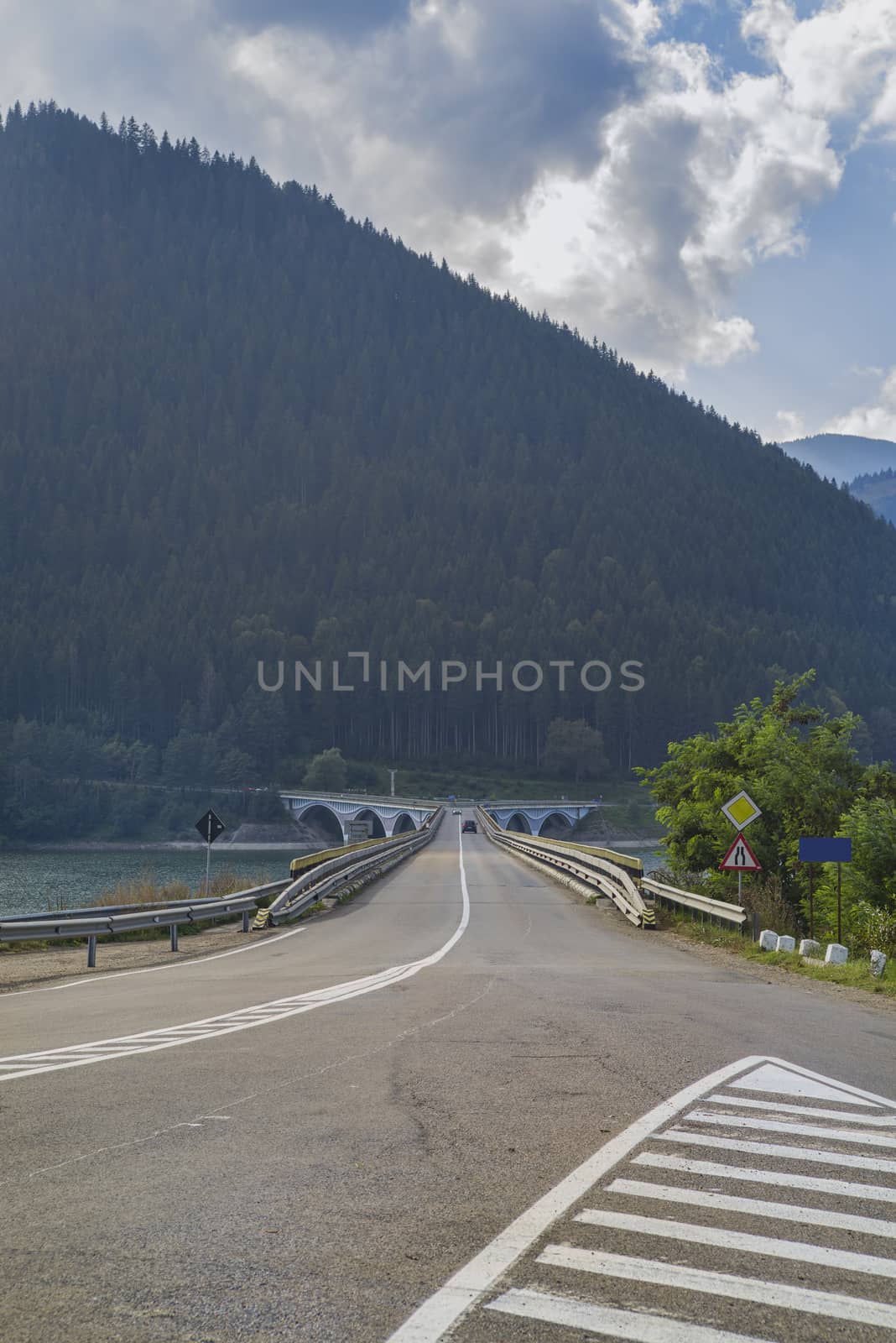 Crossing road on bridge, mountain river valley.