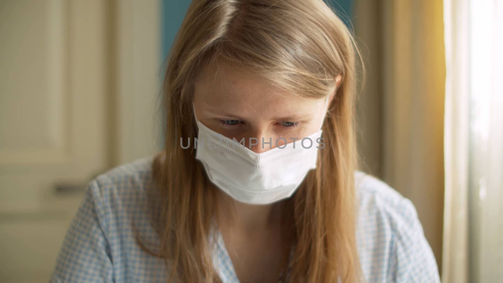 Close up portrait of a handsome woman working from home. Lady in a protective mask looking on a screen of computer. Distant job on quarantine. COVID-19 pandemic