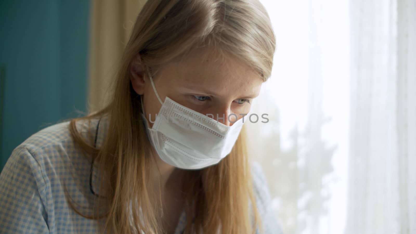 Close up portrait of a handsome woman working from home. Lady in a protective mask looking on a screen of computer. Distant job on quarantine. COVID-19 pandemic