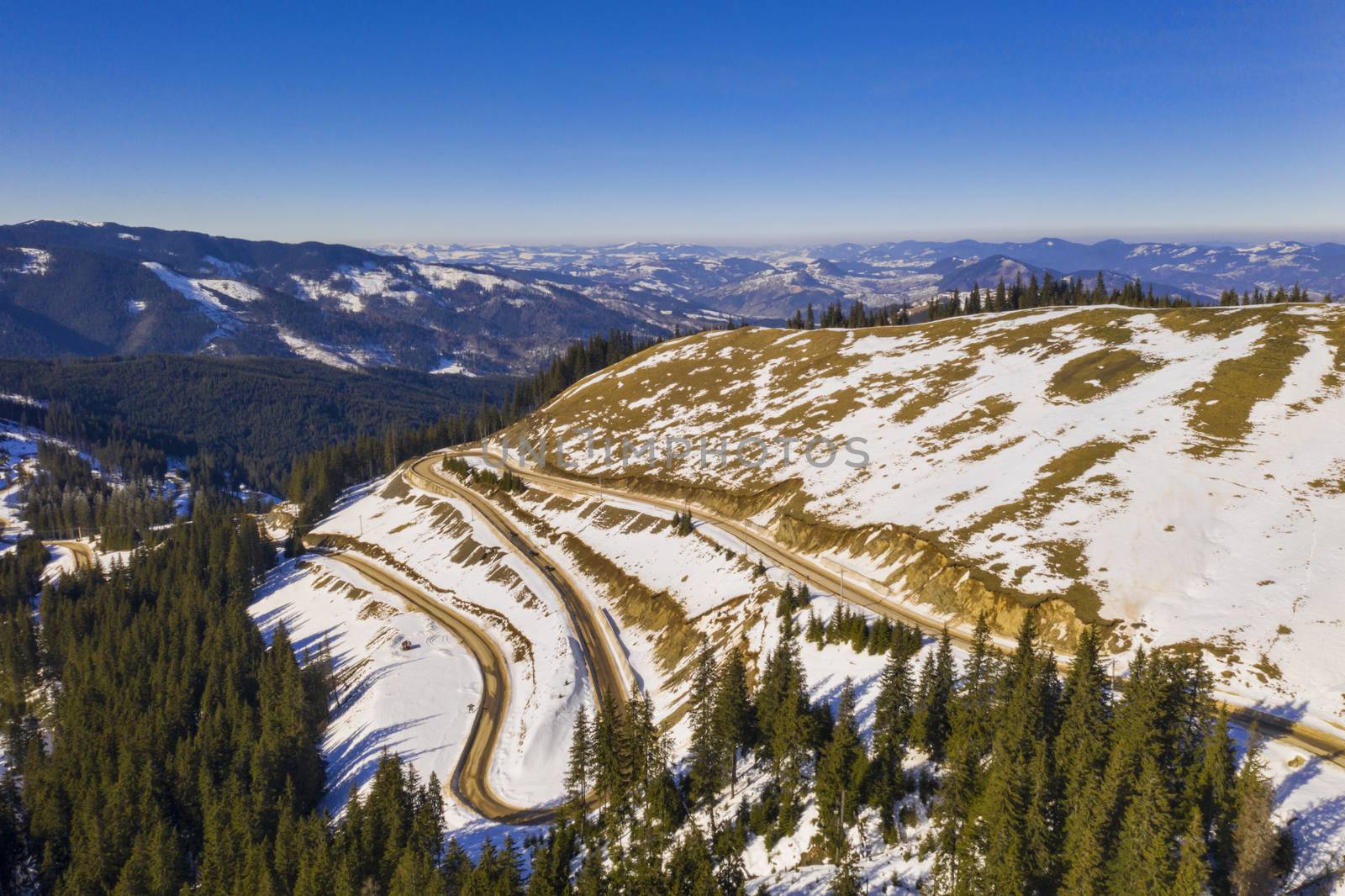 Winter curvy road in Rarau mountains, aerial scene in Romanian Carpathians.
