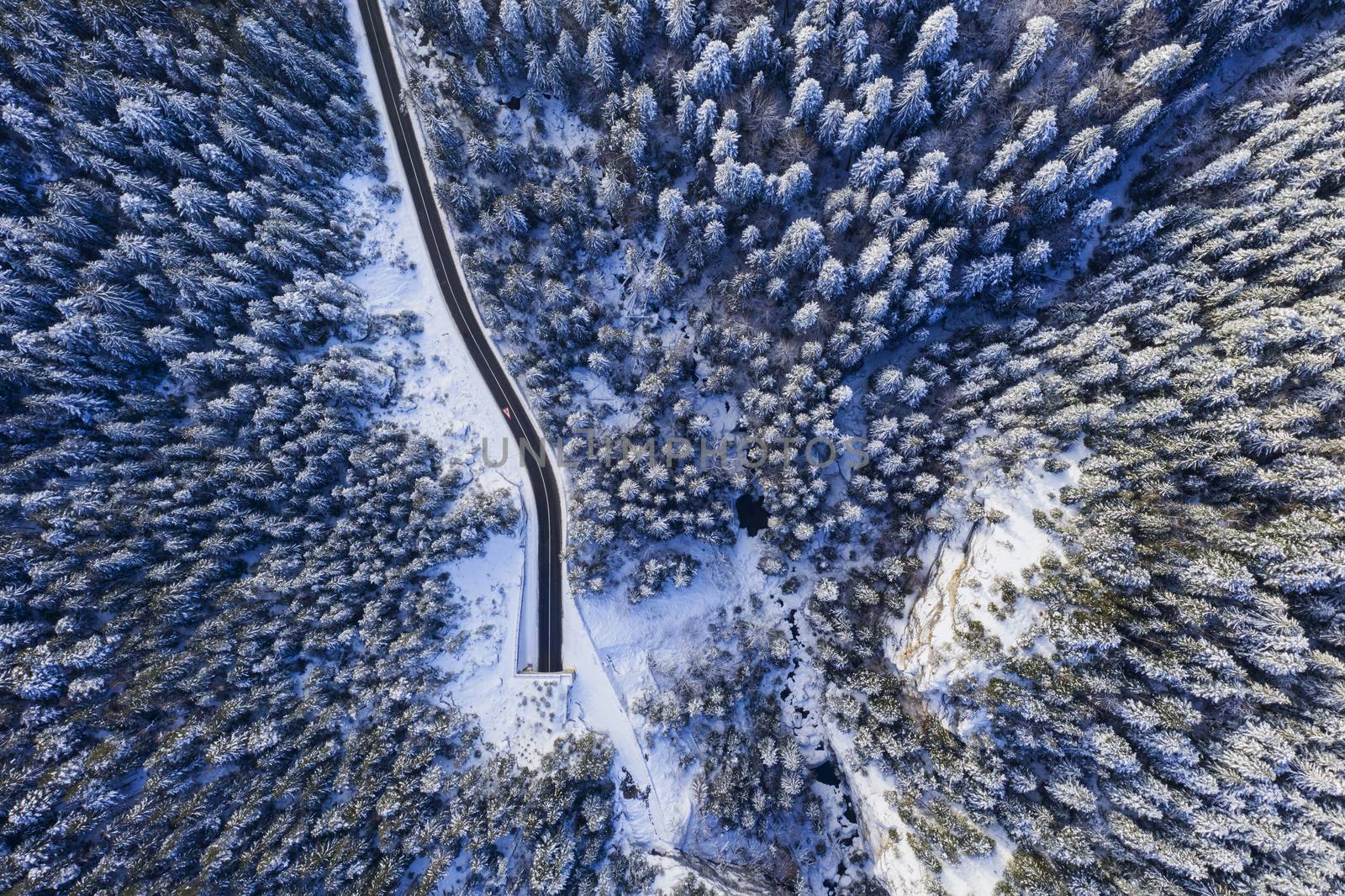 Winter forest, tunnel entrance from above, mountain curvy pass through the Romanian Carpathians.
