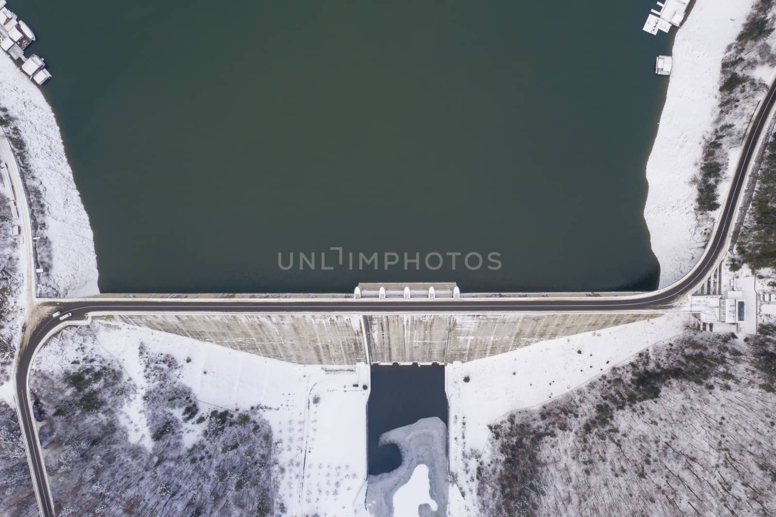 Water barriere dam viewed from above, dam and road on it in the winter. Bicaz Dam in Romanian Carpathians.
