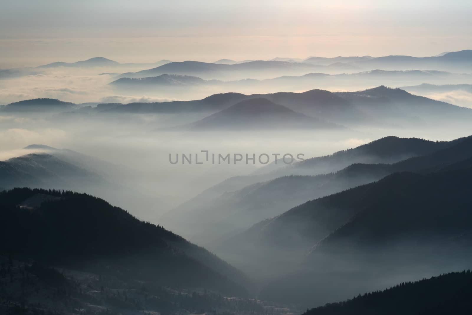 Winter landscape, crest over crest with low clouds, Romanian Carpathians.