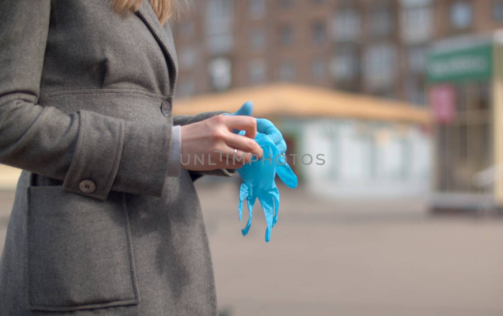 Hands of a woman putting on protective gloves by Alize