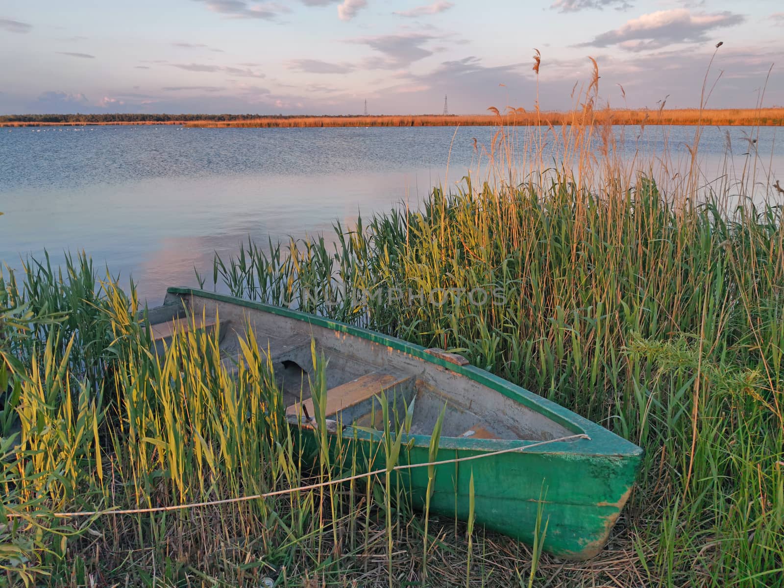 Boat anchored on the shore of Danube river at sunset