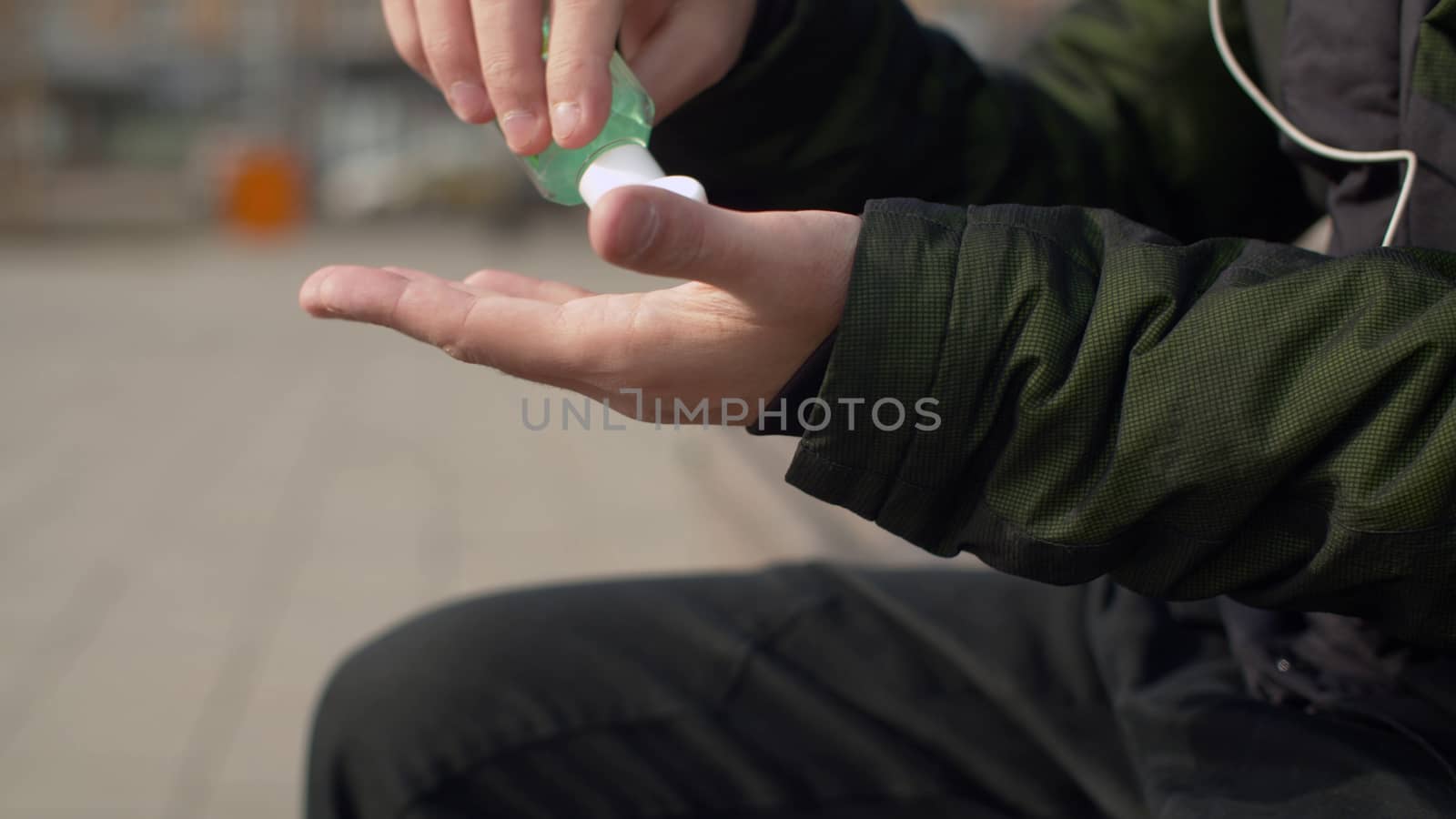 Close up young man applies antiseptic gel on his hands. Coronavirus epidemic. Concept of health and safety life. COVID-19 pandemic