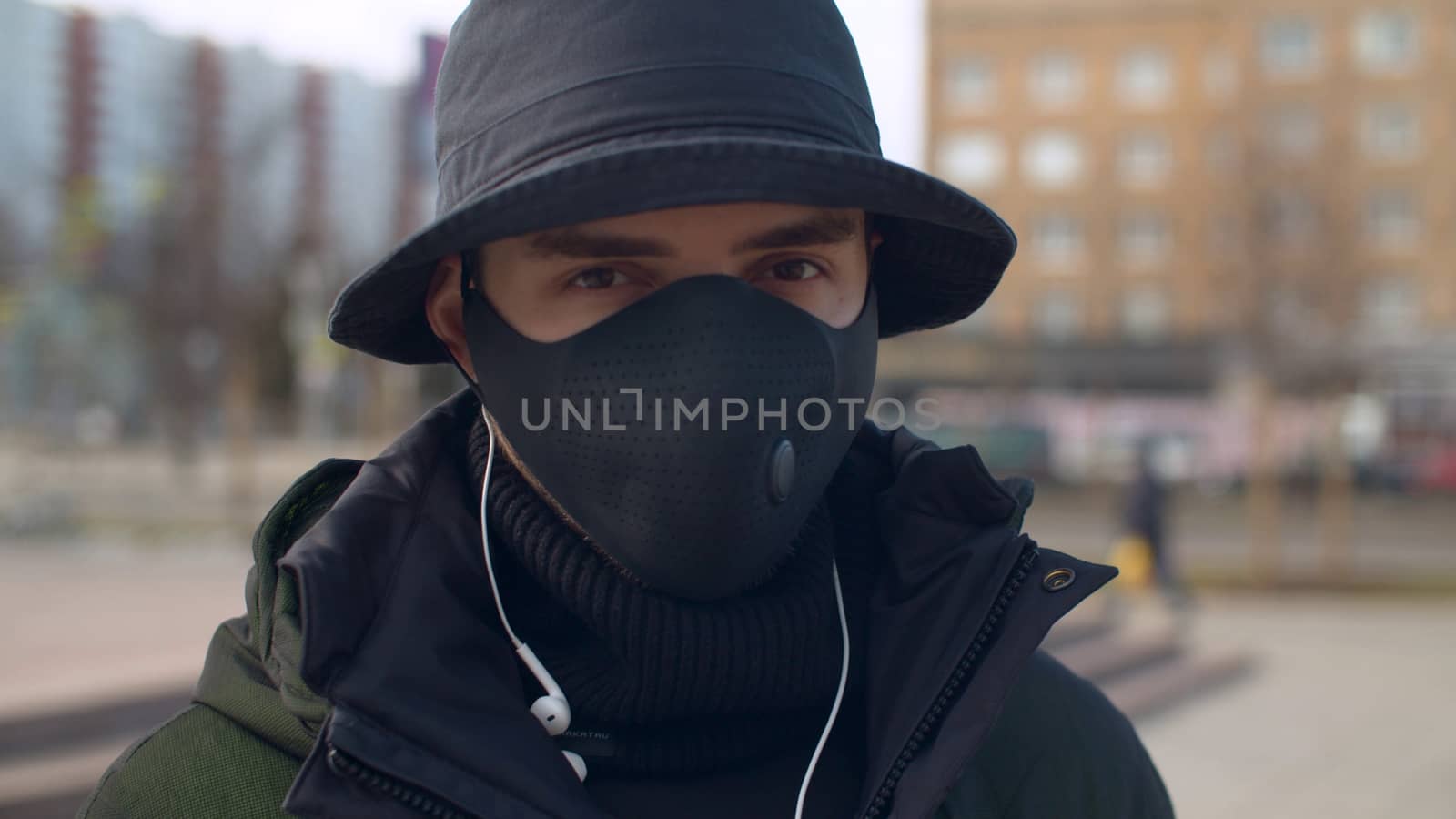 Close up portrait of a young man in a reusable face protective mask outdoors. Coronavirus epidemic in Moscow. Concept of health and safety life. COVID-19 pandemic