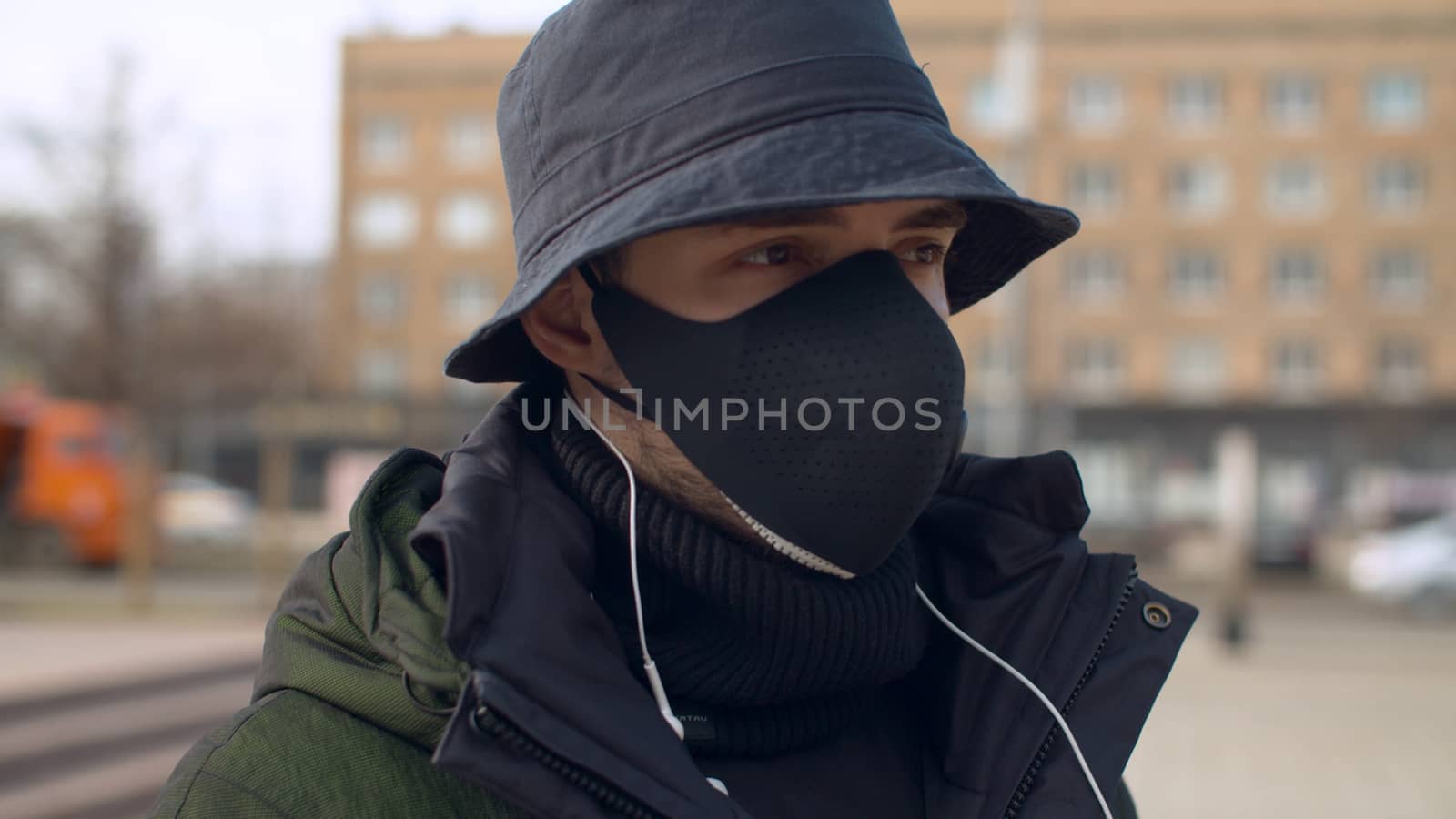 Close up portrait of a young man in a reusable face protective mask outdoors. Coronavirus epidemic in Moscow. Concept of health and safety life. COVID-19 pandemic