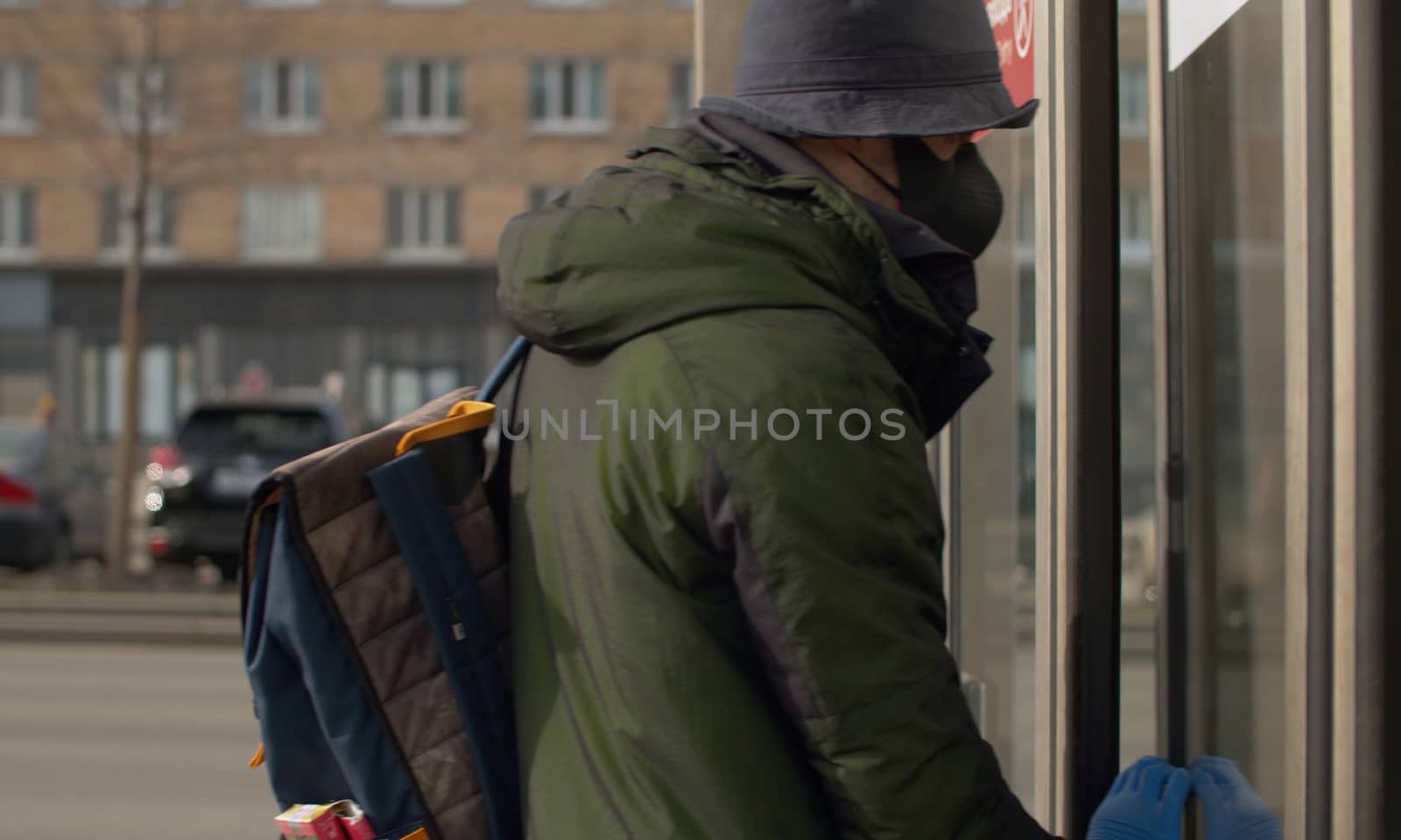 A man in a protective mask and gloves entering the subway. Coronavirus epidemic in the city. Safety life concept. COVID-19 pandemic