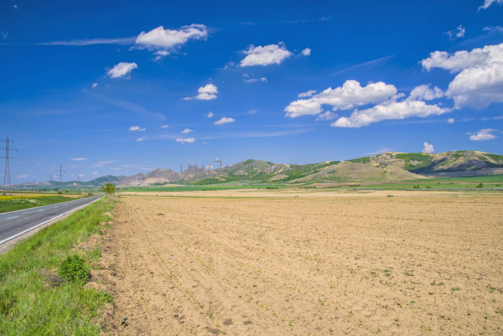 Summer view of arid fields and hill, Macin mountain landscape in Romanian Carpathians.