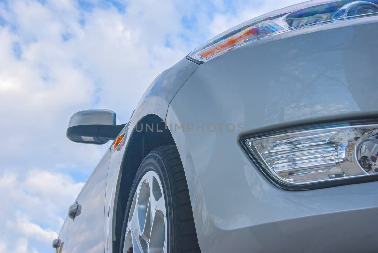 Silver shiny car with blue sky behind