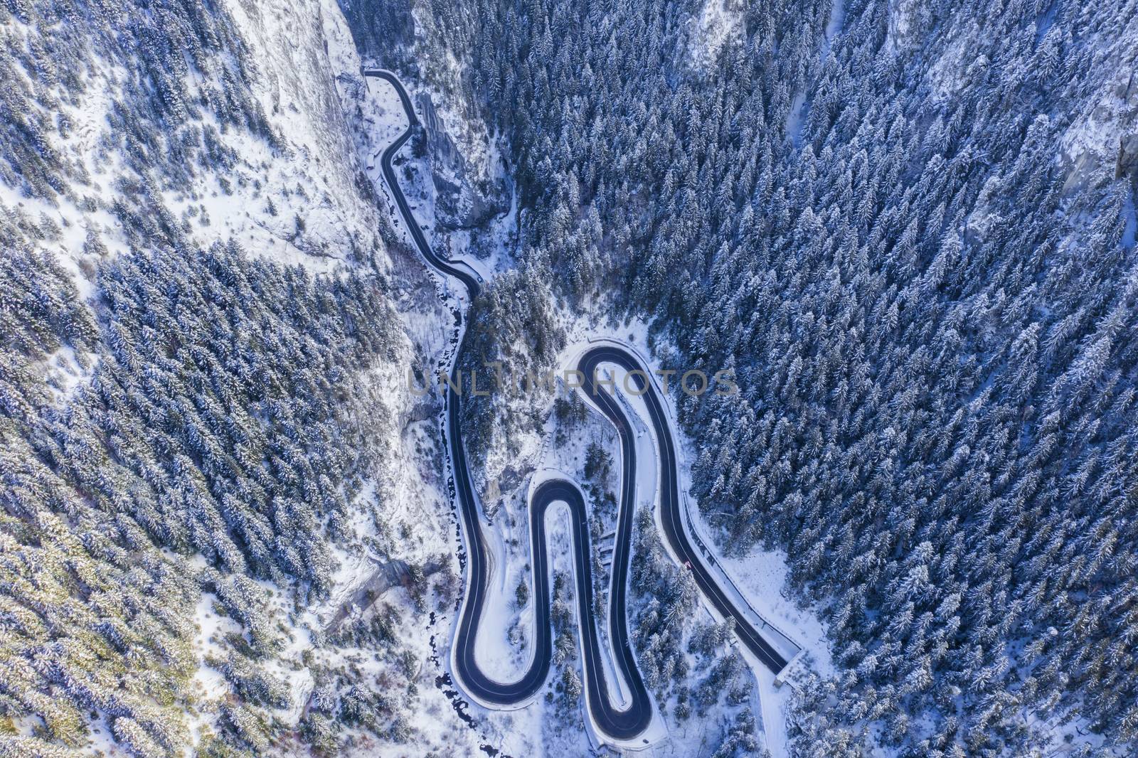 Winter mountain road from above, mountain curvy pass through the Romanian Carpathians.