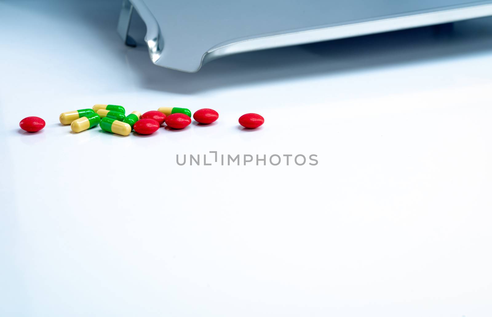 Red round sugar coated tablets and green-yellow capsules with st by Fahroni