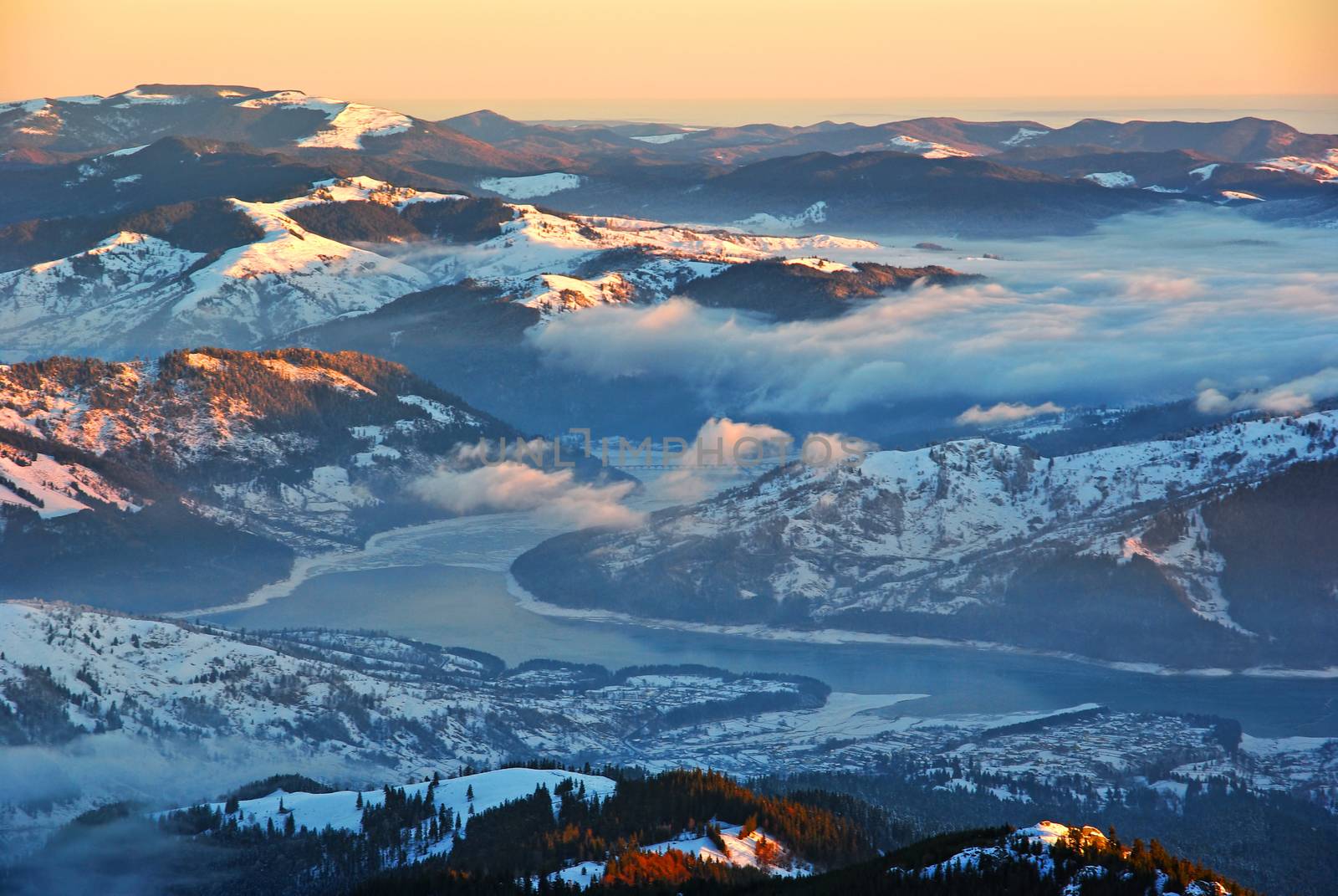 Aerial winter landscape, misty valley and mountain lake