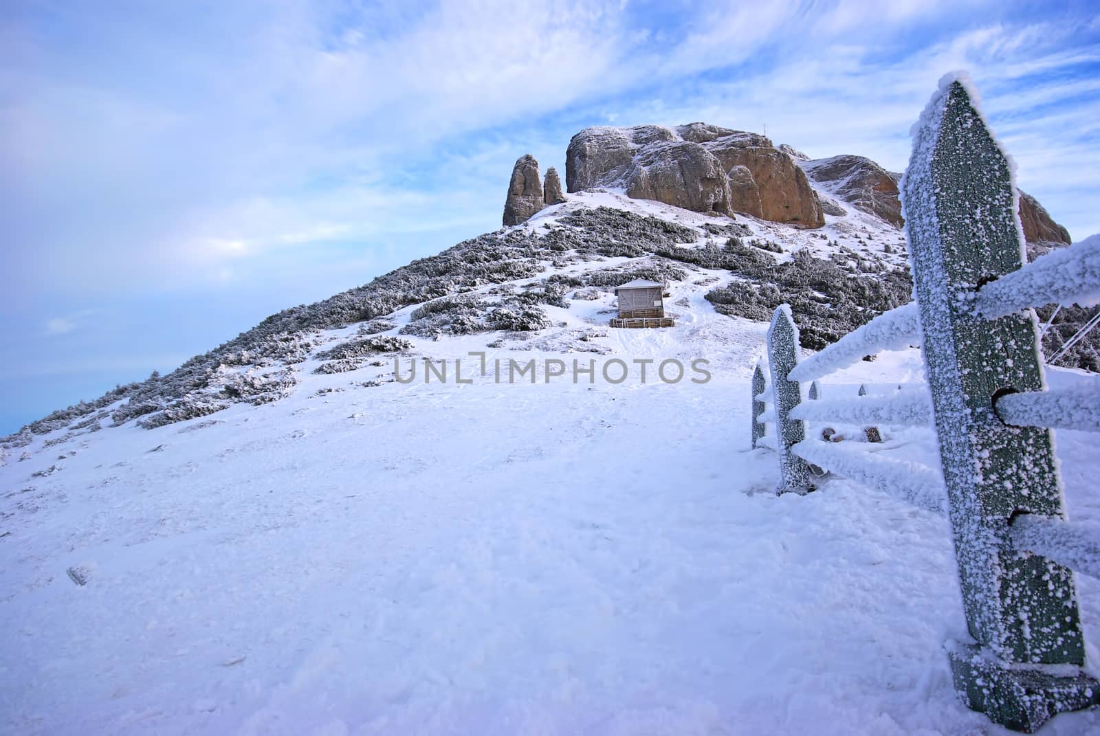 Frozen wood fence and mountain landscape in Romanian Carpathians