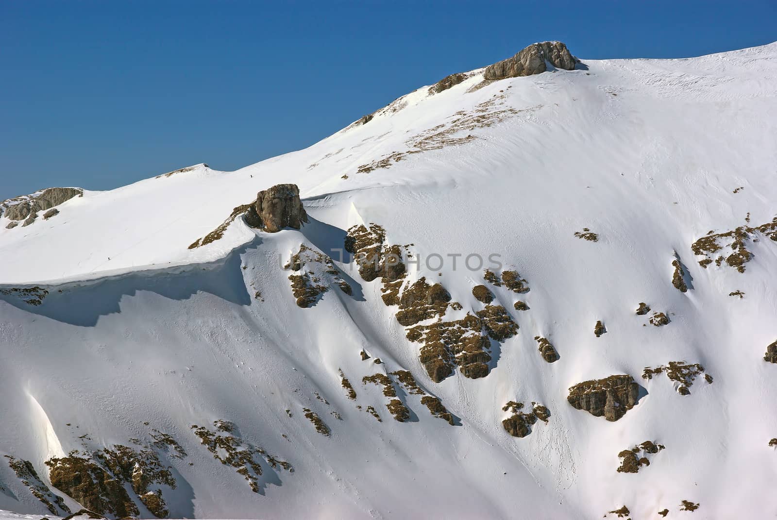 Snow covering the rocky mountain in Romanian Carpathians, winter landscape in a beautiful day