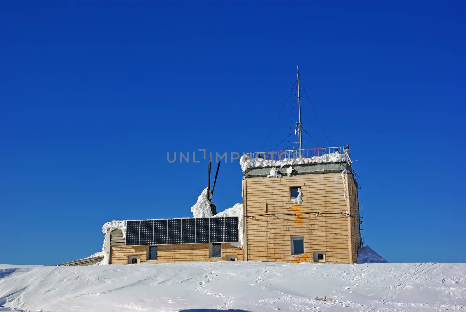 Wooden chalet with solar panels on mountain summit