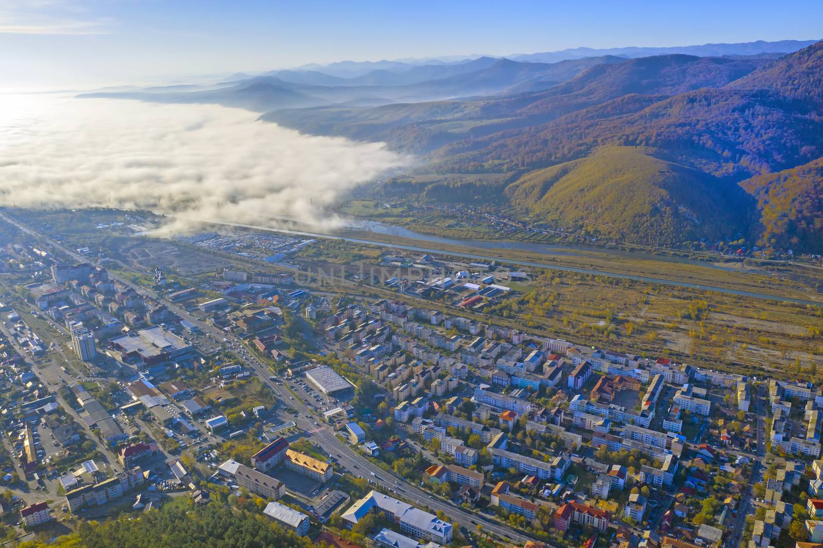 Aerial view of fog comming over the city, autumn landscape from above